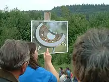 Présentation d'une reconstitution d'un théâtre antique devant un paysage de campagne