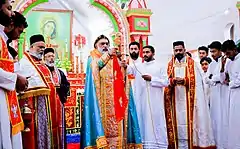 Célébration liturgique rassemblant plusieurs célébrants en habits liturgiques colorés.