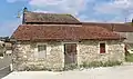 Vieux bâtiment agricole avec murs en moellons.