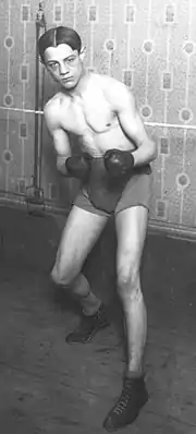Photographie en noir et blanc d'un boxeur en garde basse, poings serrés.