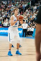 Un joueur de basket-ball au lancer-franc devant une foule nombreuse.