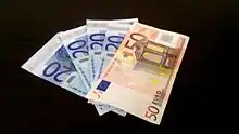 Poignée de cinq billets, quatre de 20 euros et un de 50 euros.