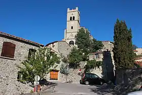 Photo de l'église vue d'en bas, de face, avec son haut clocher quadrangulaire