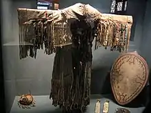 Costume de chaman, son tambour, les batteurs plats de percussion (baguettes), le chapeau et le masque utilisés pour les cérémonies