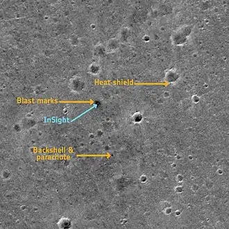 Cette image panchromatique montre le site d'atterrissage d'InSight sur Mars. Elle a été prise par l'instrument CaSSIS (Colour and Stereo Surface Imaging System) du satellite ExoMars Trace Gas Orbiter, issu de la collaboration entre l'Agence spatiale européenne et Roscosmos, le 2 mars 2019. L'image montre une surface de plus ou moins 2,25 km x 2,25 km dans la zone Elysium Planitia.