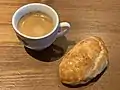 Un pogača (boradja) au fromage en France, accompagnant un expresso.