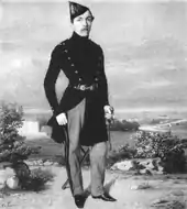 Portrait en pied de Félix Milliet, debout, habillé en costume, une canne à la main droite.