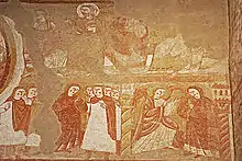 Fresque. À côté d'une scène de l'Annonciation, plusieurs personnages désignent la Vierge du doigt.