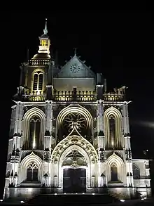 Photographie de nuit de la façade éclairée d'une église.