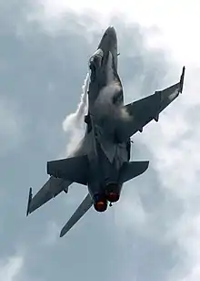 F/A-18C avec condensation de turbulences sur les becs d'attaque des ailes.
