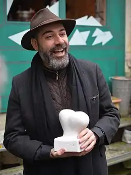 Kianoush Ramezani avec le prix "Couilles au cul".