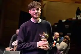 Un homme avec un prix doré dans les mains