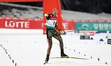 Un skieur qui lève le poing à l'arrivée d'une course.