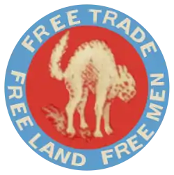 Bagdge sur lequel figure un chat de couleur beige feulant dans un disque rouge, cerclé par une couronne (au sens mathématique) bleue sur laquelle est inscrit : Free Trade Free Land Free Men