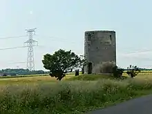 Au premier plan à droite, l'ancien moulin de la Tétaudière. En arrière-plan, une ligne électrique à haute tension, qui se raccorde au poste ÉDF de Préguillac.