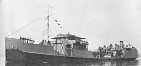 Photographie noir et blanc. Navire de guerre en mer avec des marins alignés pour la parade sur les ponts.
