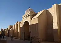 Photographie montrant les porches et les contreforts de la façade occidentale. Le porche de Bab al-Gharbi (au centre de l'image) est coiffé d'une coupole blanche côtelée.