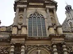 Façade principale percée d'une baie vitrée, avec un grand fronton cintré.