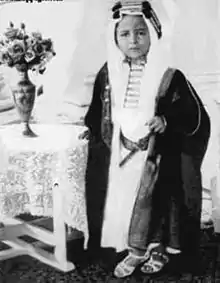 Photographie en noir et blanc d'un jeune enfant en tenue d'émir.