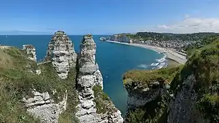 Étretat, de la chambre des demoiselles, au niveau de la passerelle, sur la falaise d'aval, à la porte d'amont, à l'horizon. Juillet 2019.