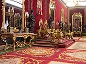 Salle du Trône aux murs recouverts de velours de Gênes cramoisi et au trône symbolique protégé par 4 lions dorés.