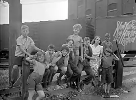 Entourée de neuf enfants du quartier Saint-Henri, devant un wagon.