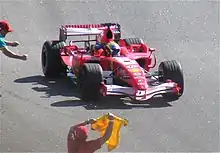 Massa, sur sa Ferrari rouge, applaudi par les commissaires de course, lui agitant différents drapeaux, au Grand Prix du Brésil 2006.