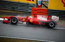 Massa pilote, sur une piste humide, sa Ferrari rouge en 2010.