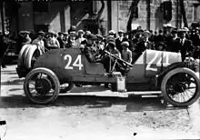 Photo d'une voiture de profil, avec, en fond, la foule.