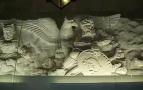 Une scène sculptée sur une frise, à l'intérieur de la tombe, représentant le mystique oiseau simurgh et le héros.