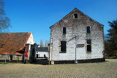 Le pignon du corps de logis et la grille d'accès.