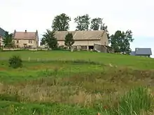 Une ferme sur une petite élévation verdoyante