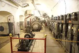 Le petit moteur CLM devant un des quatre groupes électrogènes, dans l'usine de l'ouvrage.
