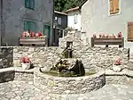 Une fontaine et abreuvoir en face de l'église.