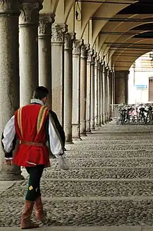 Image d'une galerie d'arcades avec un personnage en tenue de palio