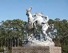 Vue d’une statue représentant deux chevaux se combattant, l’un des deux étant monté.