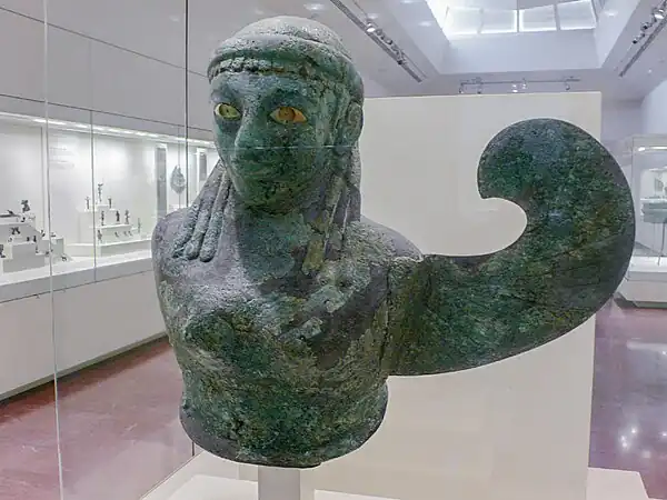 Buste en tôle de bronze, sphyrélaton. Déesse ailée avec une seule aile. H. 53,5 cm. Selon Claude Rolley : Ionie (Samos ?), 590-580 (datation : musée d'Olympie, 2009)