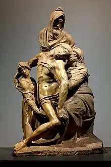 Image d'une sculpture dont les personnages sont représentés dans une composition pyramidale. Un personnage porte dans ses bras le Christ représenté comme une figure serpentine  , aidé par la Vierge Marie à droite et Marie-Madeleine à gauche.
