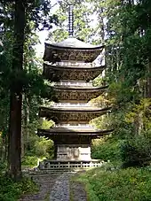 Une pagode à quatre étages en bois dans une forêt.