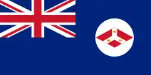 Un Blue Ensign (un drapeau bleu avce l'Union Jack dans le coin supérieur gauche) avec l'insigne des Etablissmeents des détroits (un diamant rouge avec un Y inversé; à l'intérieur duquel trois couronnes.