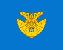 Un symbole doré dur fond bleu. Le symbole doré est un aigle perché sur une paire d'ailes.