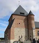 Le donjon sur une assise en grès, qui comporte des motifs en briques vernissées, est renforcé par deux importants contreforts d'angle. Des meurtrières assuraient la défense de l'église.