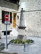 Vue d'une fontaine en pierre devant une maison.