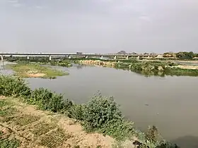 Lit du cours d'eau Bénoué en période sèche. Le pont en arrière-plan.