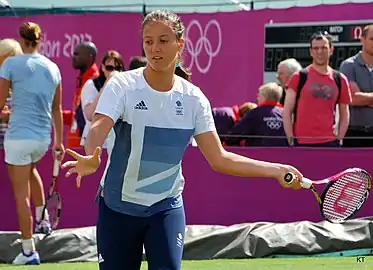 Une joueuse de tennis fait un coup droit en tenue olympique britannique.
