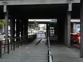 Sous le pont de la gare avec accès ascenseur.