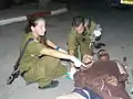 Palestinien recevant des soins de la part d'une soldate et d'un soldat d'IDF