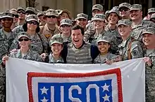 Colbert pose avec des soldats devant l'ancien palais de Saddam Hussein.