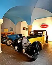 Photographie d'une salle voûtée contenant deux voitures haut de gamme de l'entre-deux-guerres.