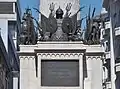 Plaque et trophées sur la fontaine.